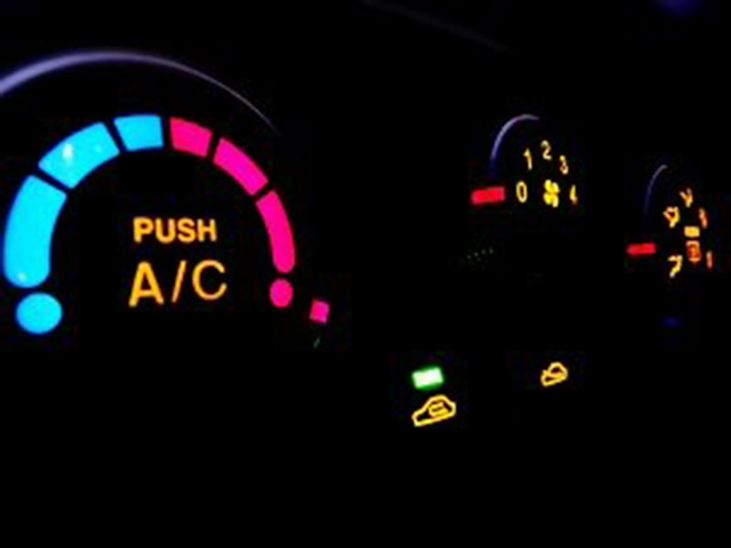 Close-up of illuminated car dashboard controls in the dark