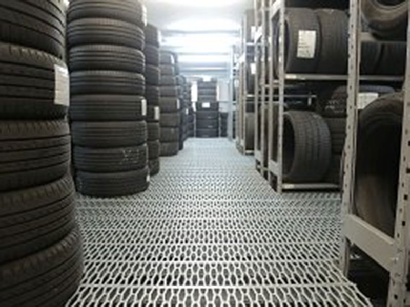 Rows of stacked tires are organized on metal shelves